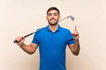 Young handsome golfer man over isolated background pointing up a great idea