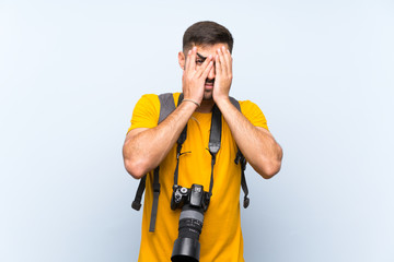 Young photographer man covering eyes and looking through fingers