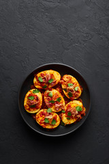 Golden Egg Curry in black bowl at dark slate background. Burmese Egg Curry is popular Myanmar Cuisine dish with duck or chicken eggs, tomatoes, ginger, onion, cilantro and spices.
