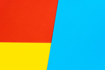 Fototapeta premium Yelllow blue red color paper background. Geometric figures, shapes. Abstract geometric flat composition. Empty space on monochrome cardboard