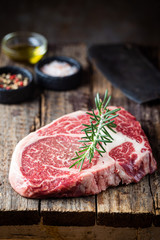 Fototapeta na wymiar Raw fresh meat Ribeye Steak and seasonings on wooden background, rustic style
