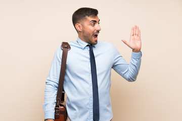 Young business with beard over isolated background shouting with mouth wide open