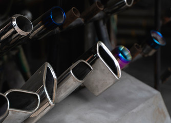 New and used motorcycle exhaust chrome pipes in a motorcykles shop or in service center.