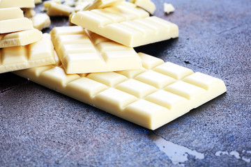white broken chocolate and cocoa bar. Pieces of white chocolate on rustic background