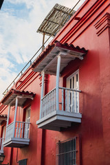 Fototapeta na wymiar Wooden balcony in colorful wall. Colorful architecture in Santa Marta, Colombia.