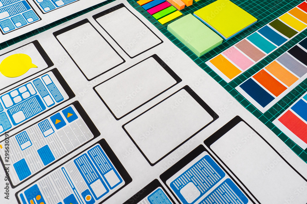 Poster paper on the desktop of the mobile app designer. templates for ease of use. new applications for mob