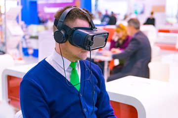 Testing of the virtual reality device. A virtual reality helmet is worn by a man. Immersion in the...