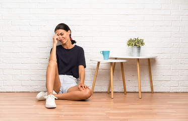 Young woman sitting on the floor laughing