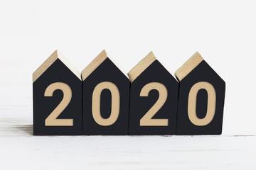 New Year 2020 inscription on wooden cubes in the shape of a house on a white wooden background, New Year concept