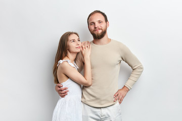 Fototapeta premium confident man with a hand on his hip hugging his woman, is being proud of his wife, close up portrait, isolated white background, studio shot,family