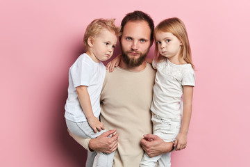 funny serious frowning their eyebrows father and children making faces, close up portrait, isolated pink backgrround, reaction, facial expression