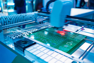 Fragment of the CNC machine. Equipment for PCB Assembly. Production automation. The robot fixes the electronic components on the Board in accordance with the specified program. - obrazy, fototapety, plakaty