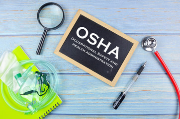 Osha, Occupational Safety and Health Administration. Blackboard on a wooden background.