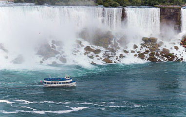 Fototapeta premium Cataratas del Niagara con una barca de turistas de color azul