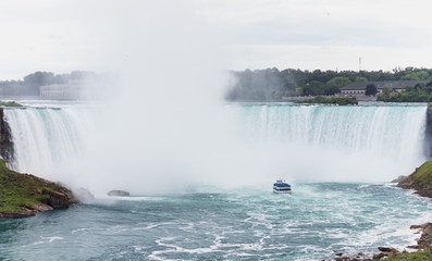 Cataratas del Niagara con una barca de turistas de color azul