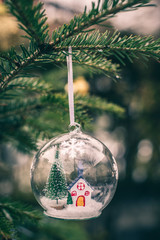 Transparent cristalball with christmas tree and house inside.