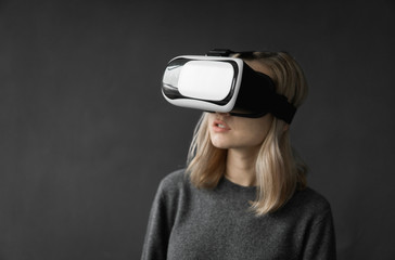 Young woman wearing virtual reality goggles headset, vr box. Connection, technology, new generation, progress concept. Girl trying to touch objects in virtual reality.