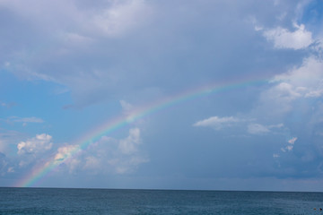 Black calm sea in Sochi and a rainbow in the morning