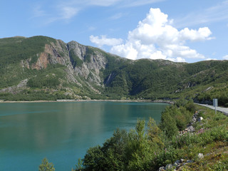 a beautiful landscape with mountains in the background and a blue fjord in the foreground