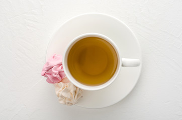 Cup of tea with marshmallows on a white background.