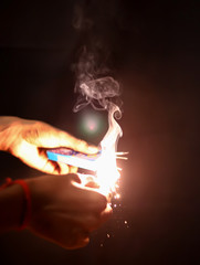 hand holding matchstick sparklers over black background