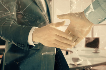 Multi exposure of tech theme hologram on office background with two men handshake. Concept of technology