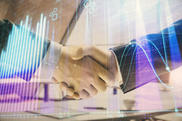 Multi exposure of financial graph on office background with two businessmen handshake. Concept of success in business