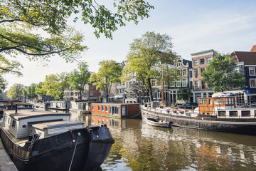 Fototapeta na wymiar Street and canals in Amsterdam old town, Netherlands. Popular travel destination and tourist attraction