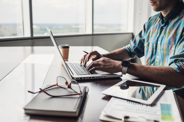 Businessman working on computer. Men using laptop and digital tablet in the office. Internet...