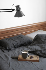 Coffee latte and chocolate in unmade bed