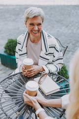 Cheerful female sitting in a cafe outdoors