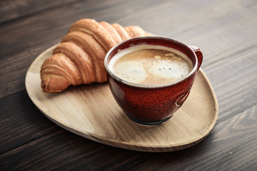 Coffee cup and fresh baked croissant