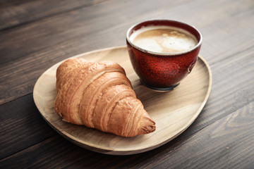 Coffee cup and fresh baked croissant