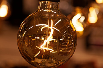 light bulb in with filament in close-up and bokeh background