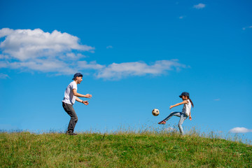 草原でサッカーボールで遊ぶ父と子供 © hakase420