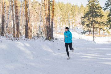 Winter cross-country exercise. Runner runs in the snow. Young female fitness model doing sports in the cold season, hardening. the concept of health
