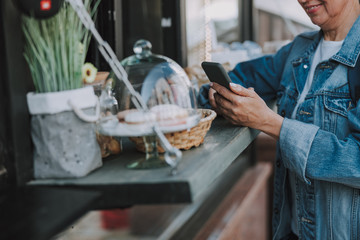 Woman with a smartphone standing near a kiosk