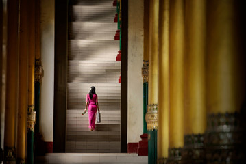 A Burmese national girl in a national costume, walking and visiting landmarks in the Shwedagon Pagoda at Yangon, Myanmar.