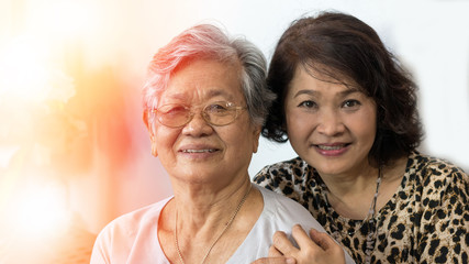 Happy Asia senior mother and adult daughter concept. Portrait of Asian family older ageing women and caregiver smiling with happiness at home, or wellbeing county  hospice.