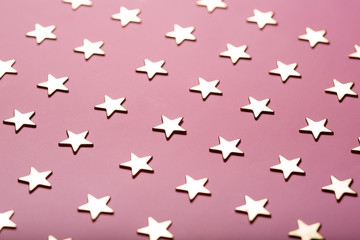 Festive composition with golden stars on dusty pink background