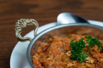 Closeup of Turkish meze, acili ezme or spicy paste isolated on wooden background