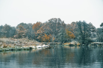 The first snow falls on the autumn river