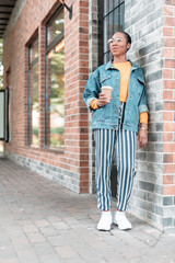 Jolly woman enjoying hot drink in city stock photo