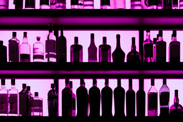 Rows of bottles sitting on shelf in a bar