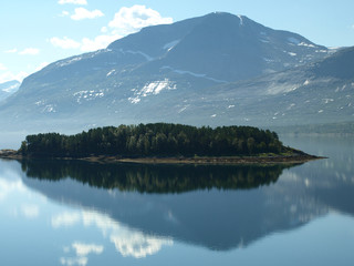 Naklejka premium landscape with smoky mountains in the background and blue water in the foreground, beautiful blurry glare