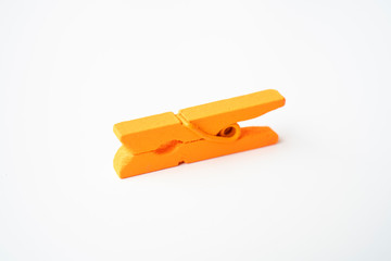 Orange wooden clothespins on a white background.