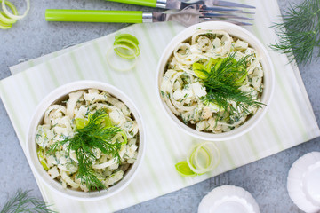 Salad with leek and eggs in portioned white bowls, horizontal, top view