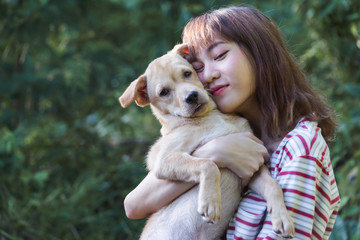 Portrait girl hug with her puppy on nature background.