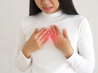 gastroesophageal reflux disease or GERD breathing difficulty in asian woman. She use hand touching chest on isolated white background use for health care concept.