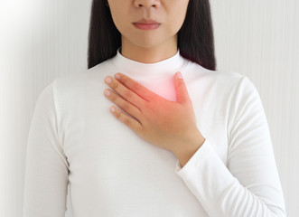 gastroesophageal reflux disease or GERD breathing difficulty in asian woman. She use hand touching chest on isolated white background use for health care concept.